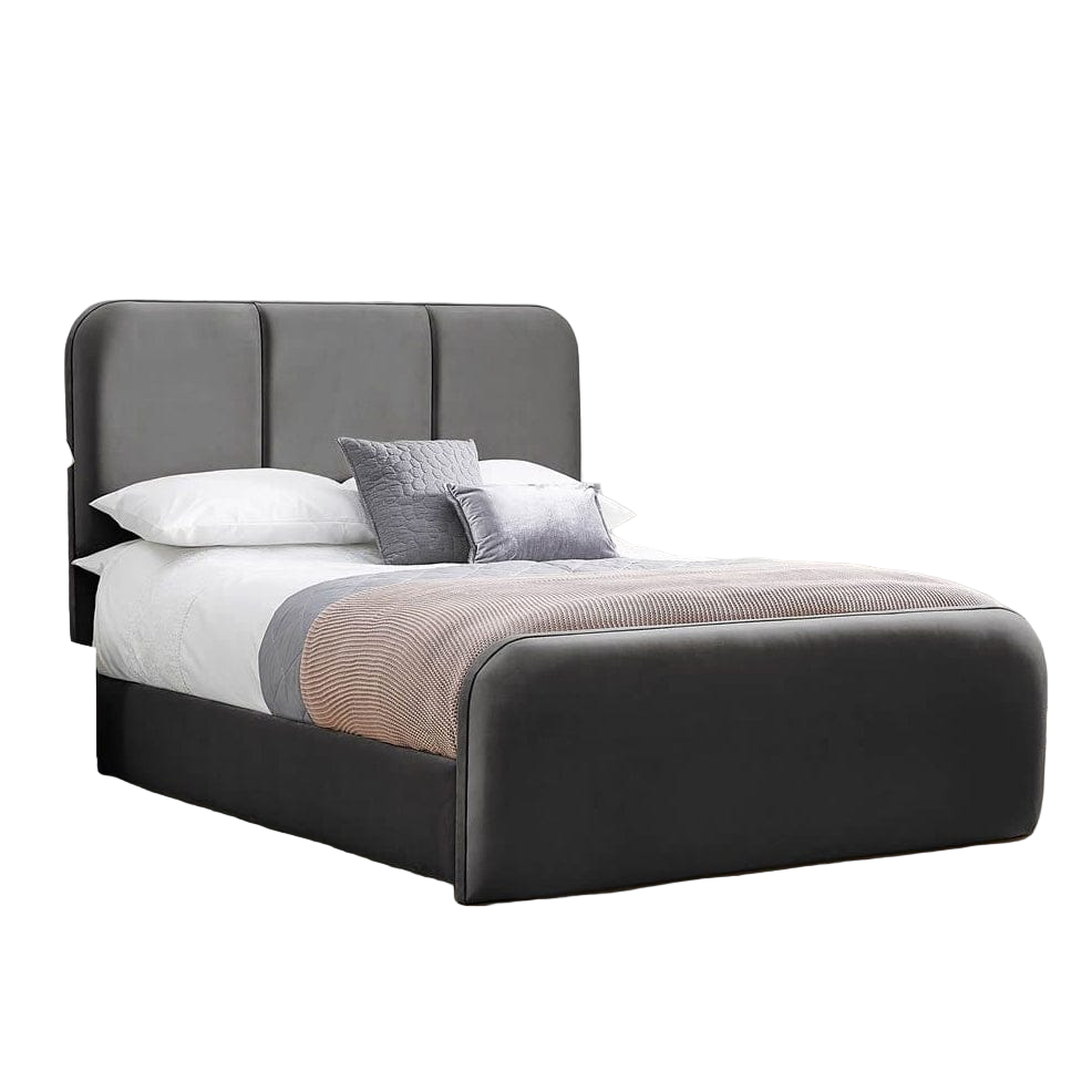 Gray upholstered bed in a bedroom setting with a wooden nightstand and rug.