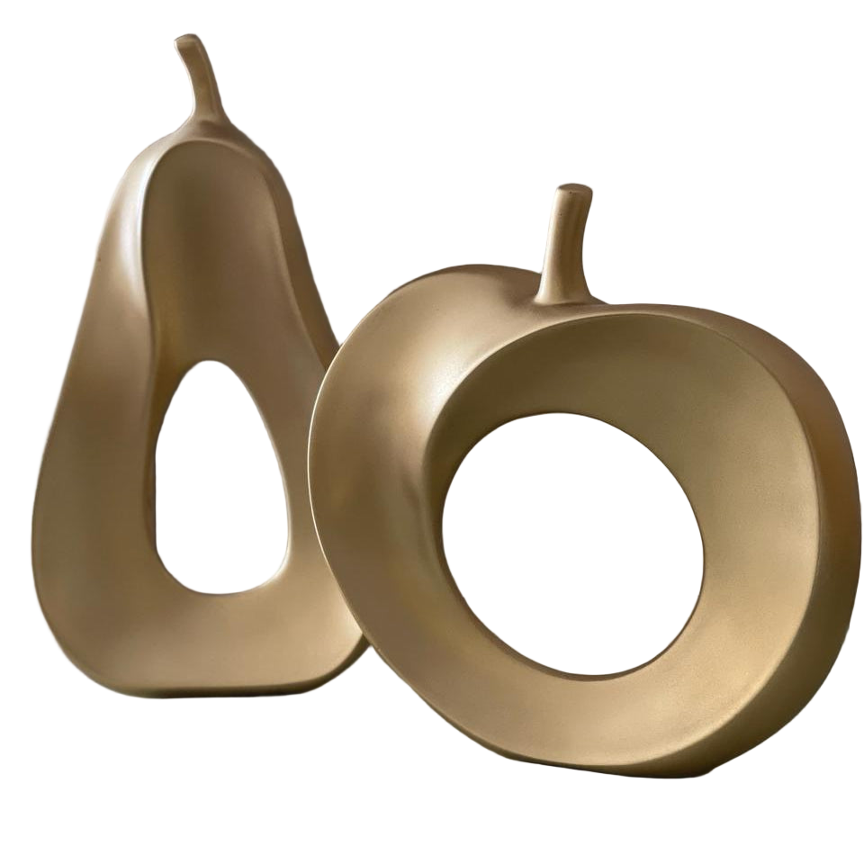 Two gold decorative objects shaped like pears on a reflective surface.