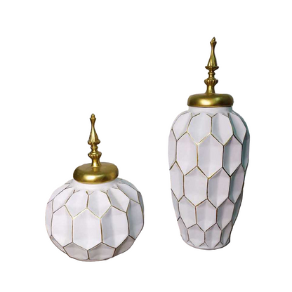 Two decorative vases with geometric patterns and gold accents on a wooden surface.