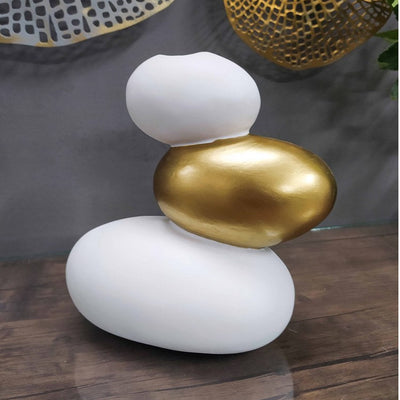 Decorative sculpture with white and gold elements on a wooden surface