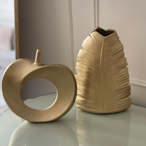 Two decorative vases on a reflective surface with a neutral background