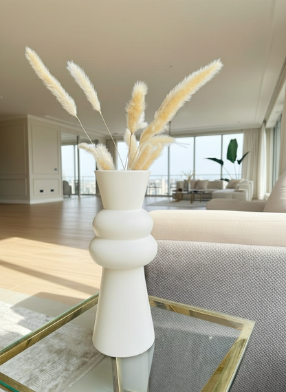 Decorative vase with dried plants on a coffee table in a living room setting