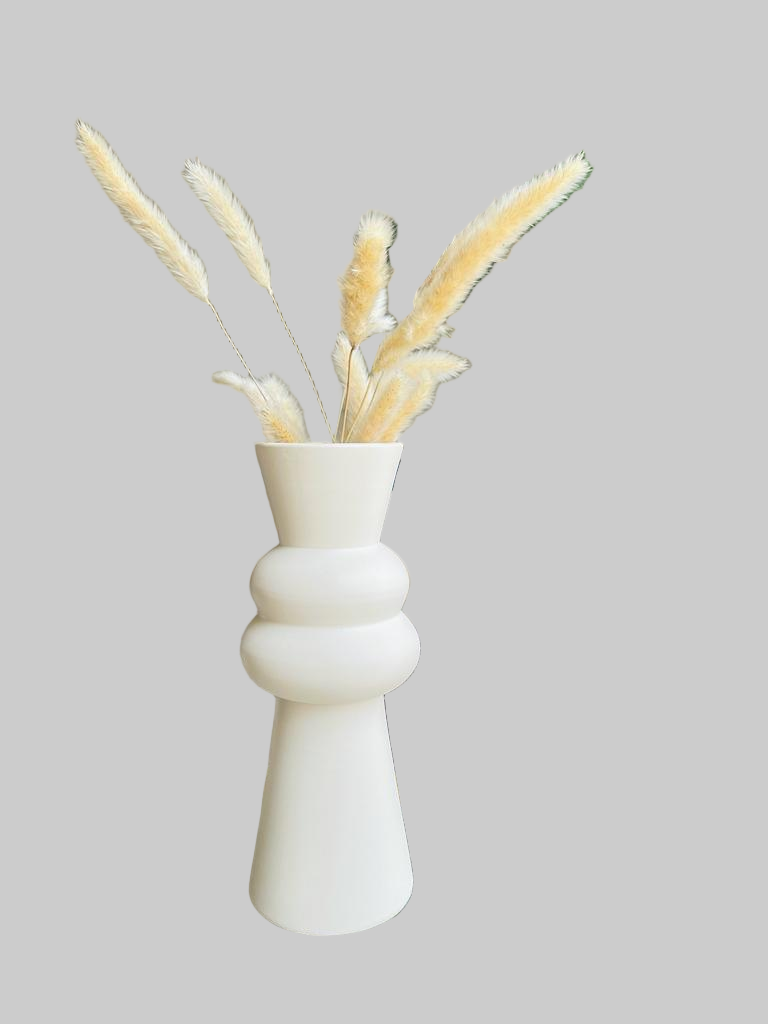 Decorative vase with dried plants on a coffee table in a living room setting