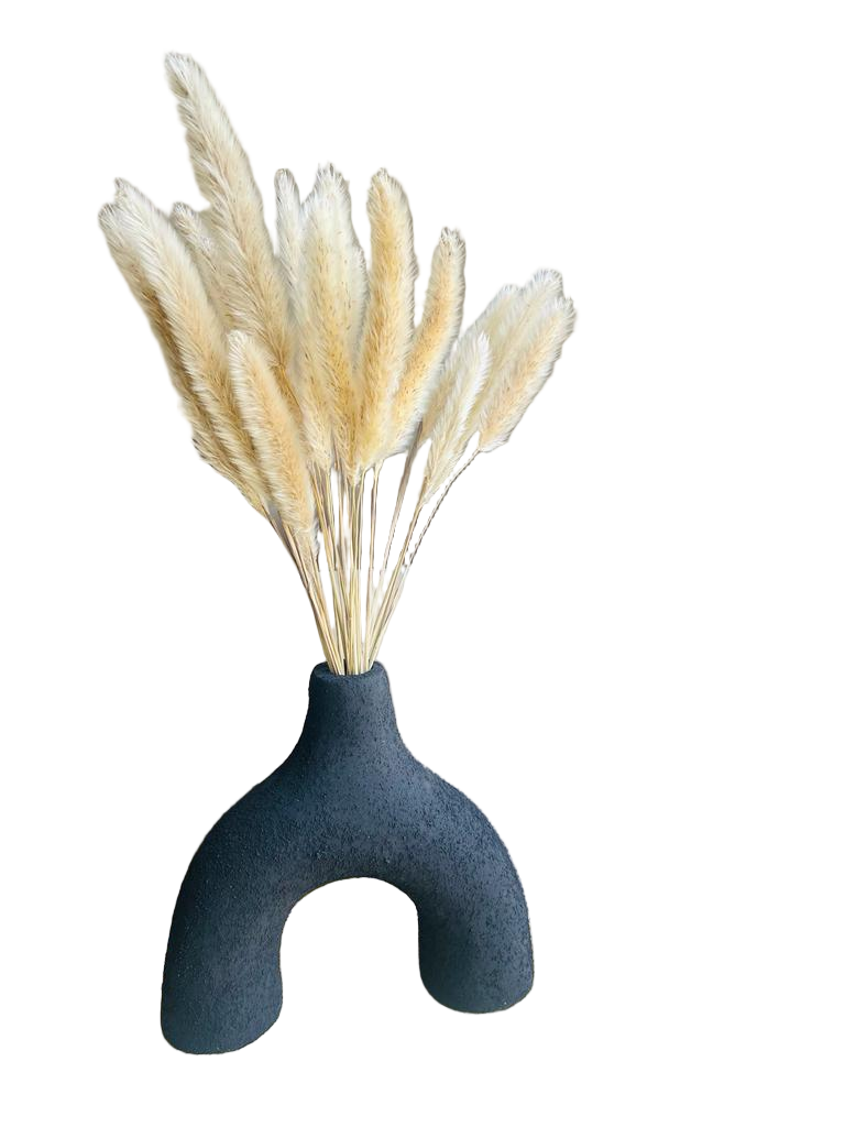 Decorative vase with dried pampas grass on a table in a living room setting.