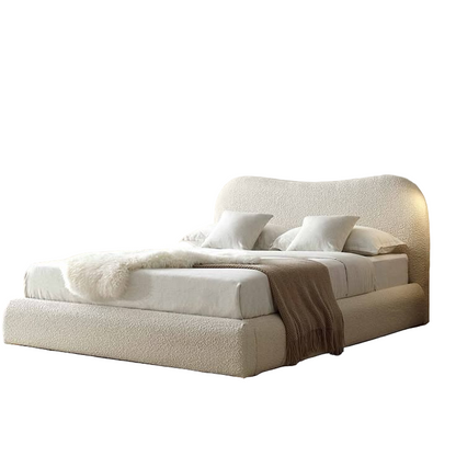 Beige upholstered bed with white pillows on a white background