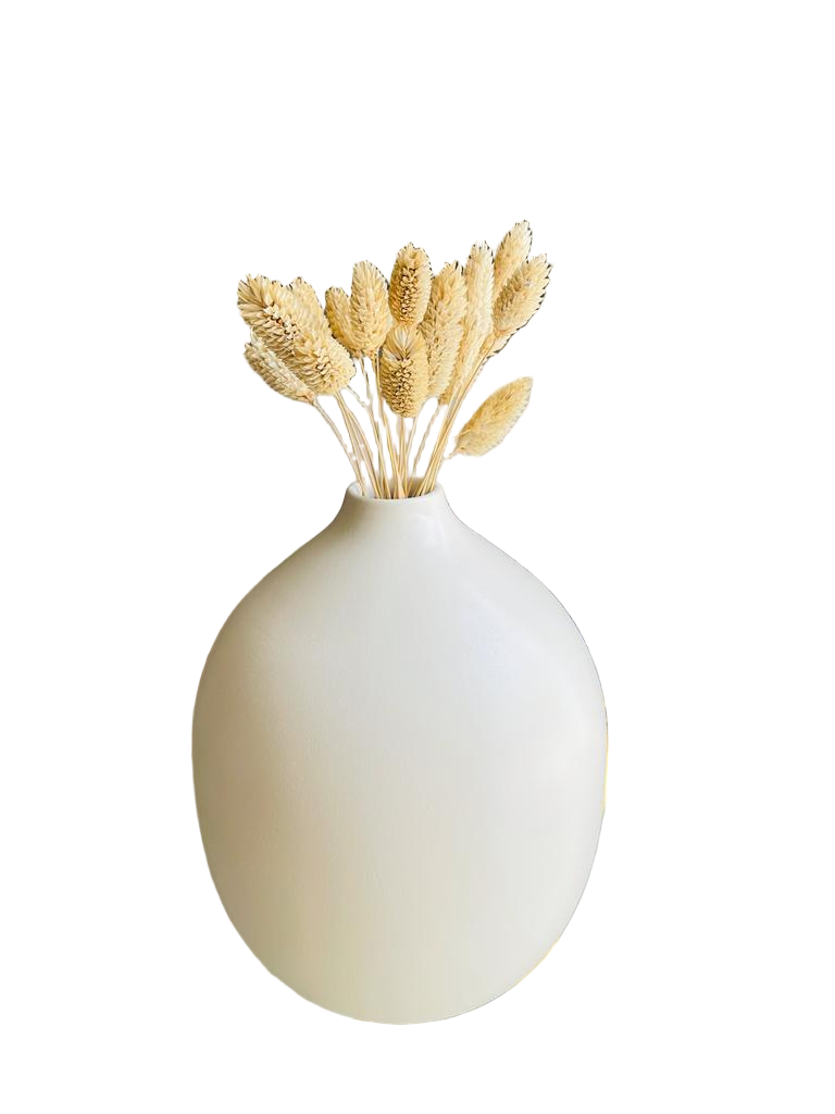 White vase with dried wheat on a table in a room setting