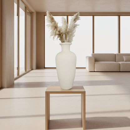 White vase with dried plants on a wooden table in a minimalistic living room.