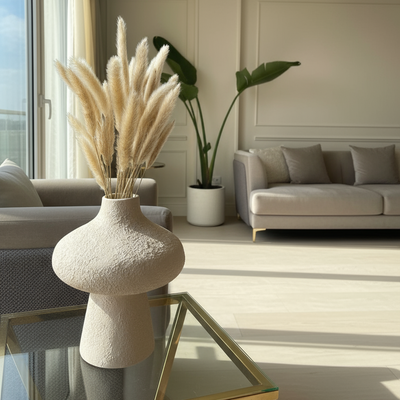Modern living room with a vase of dried plants on a coffee table.