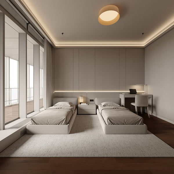 Modern bedroom with three beds and a desk against a wall with built-in lighting.