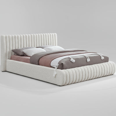 Bed with textured headboard and bedding on a white background