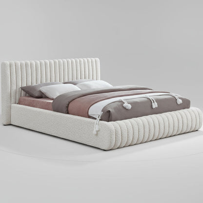 Bed with textured headboard and bedding on a white background