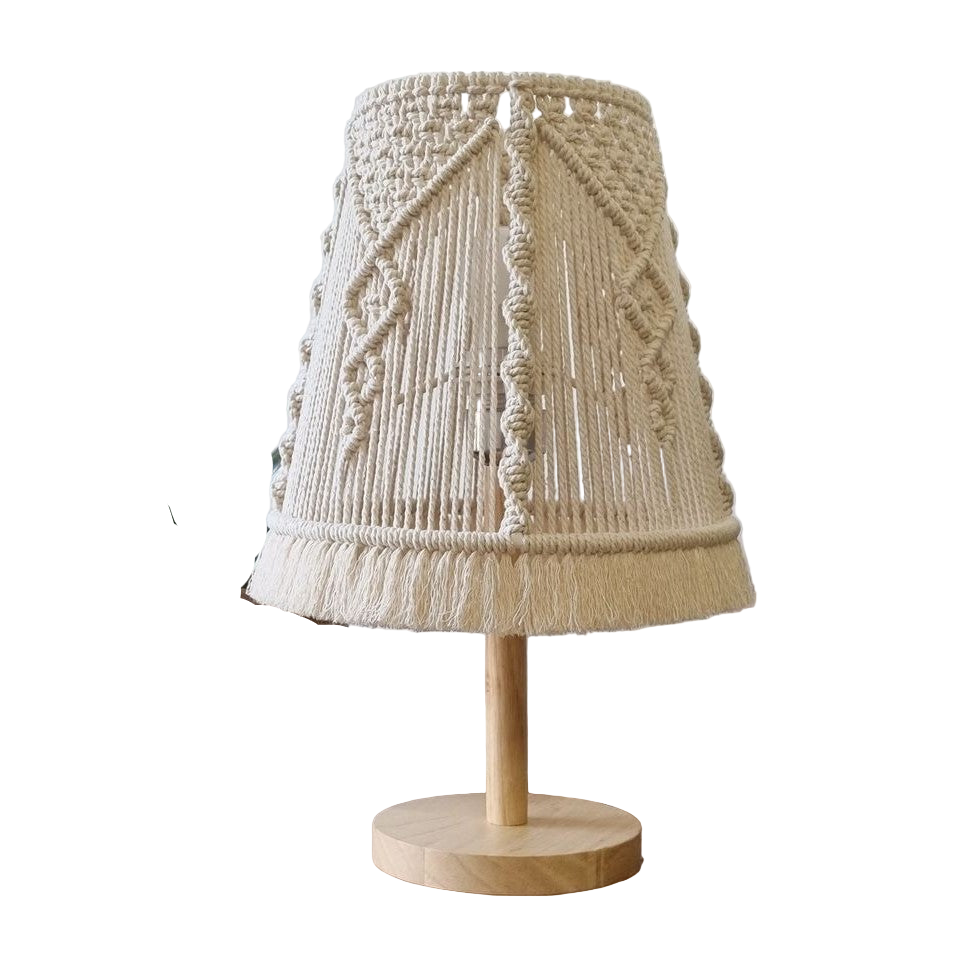 Lamp with a textured beige shade on a wooden base, placed on a surface with a plant in the background.