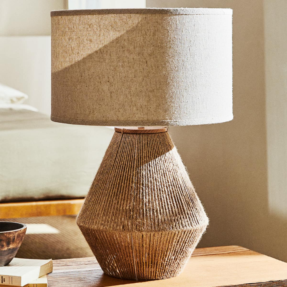 Woven lamp with a geometric design on a wooden surface.