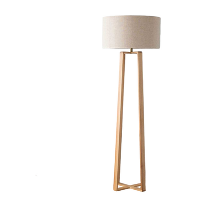 Wooden floor lamp next to a side table with decor items against a light blue wall.