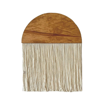 Wooden wall art with string fringe on a white background