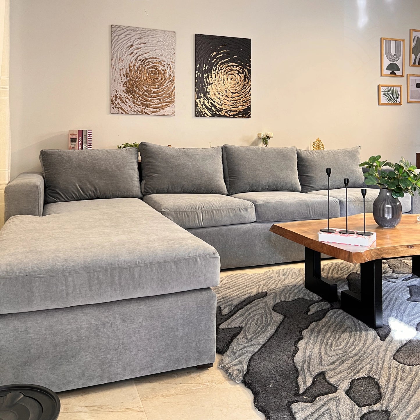 Modern living room with gray sectional sofa, wooden coffee table, and decorative wall art.