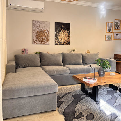 Living room with a gray sectional sofa, wooden coffee table, and decorative elements.
