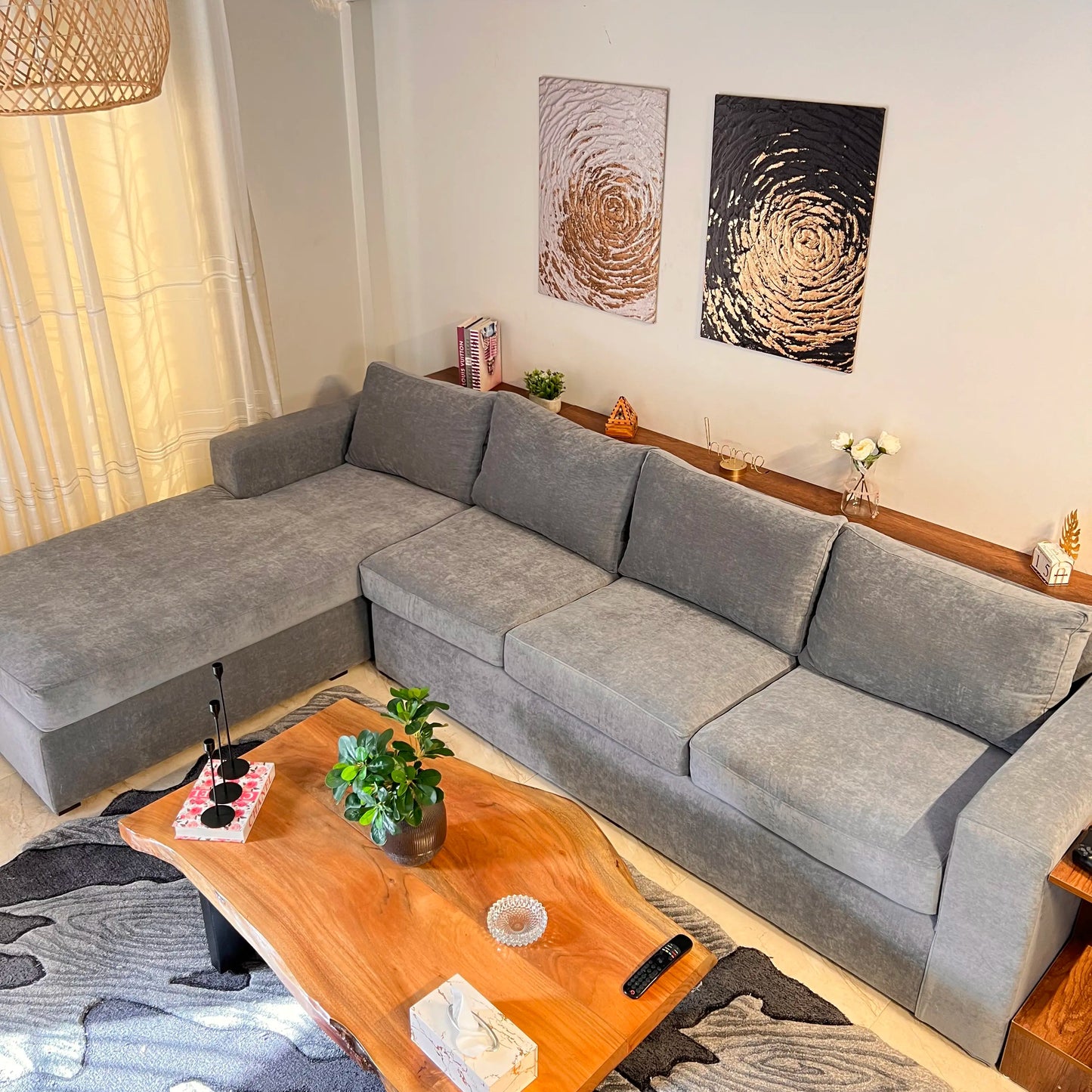 Living room with a gray sectional sofa, wooden coffee table, and decorative elements.