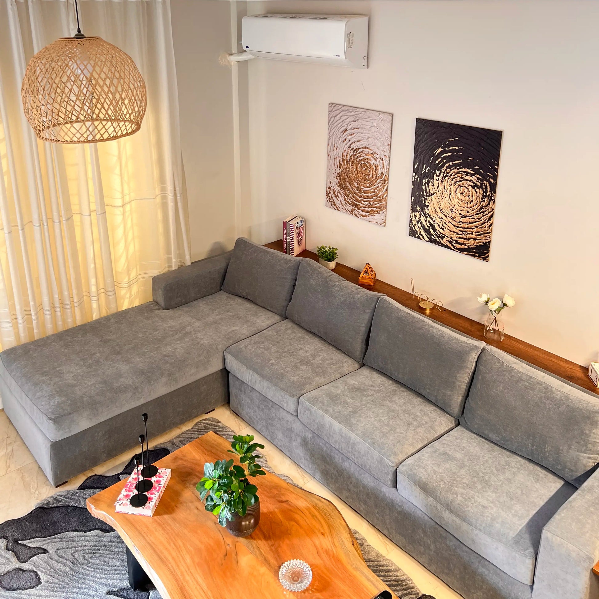 Gray sectional sofa in a living room with wooden coffee table and wall art.