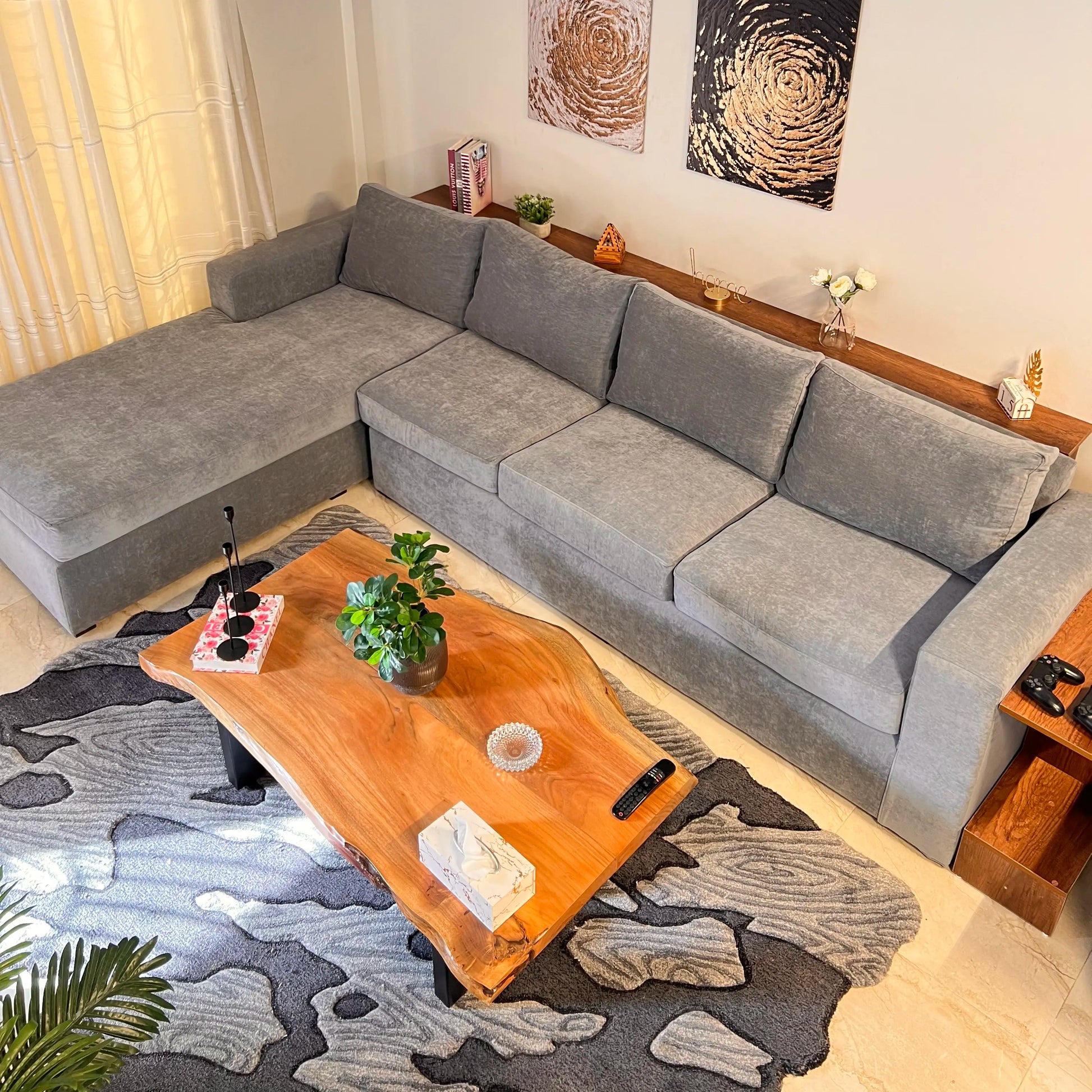 Living room with a gray sectional sofa, wooden coffee table, and decorative elements.