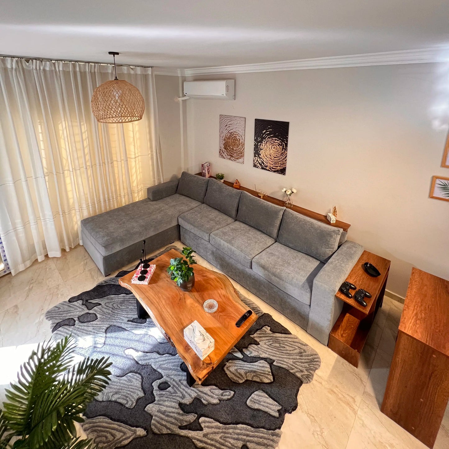 Living room with a gray sectional sofa, wooden coffee table, and decorative elements.