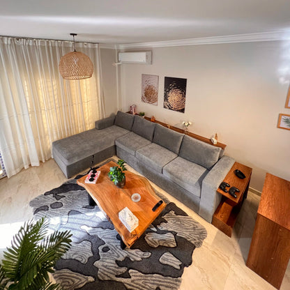 Living room with a gray sectional sofa, wooden coffee table, and decorative elements.