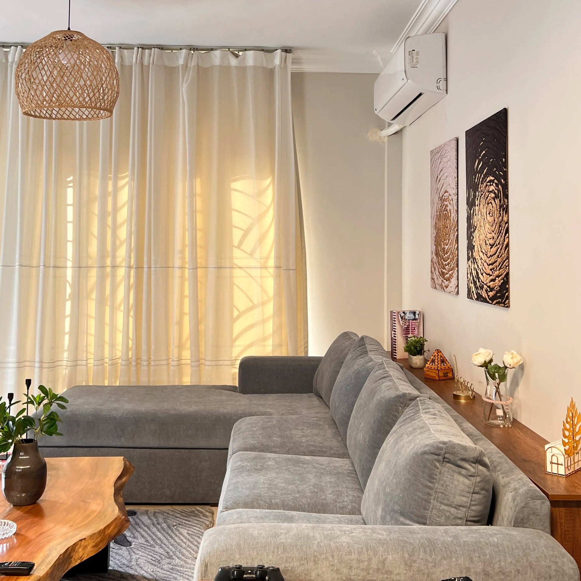 Modern living room with a gray sectional sofa, wooden coffee table, and decorative elements.