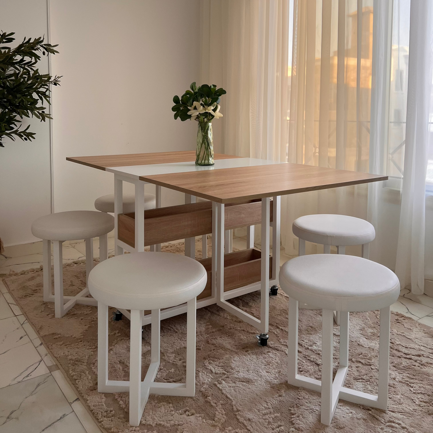 Dining area with a wooden table, stools, and a bench in a well-lit room.