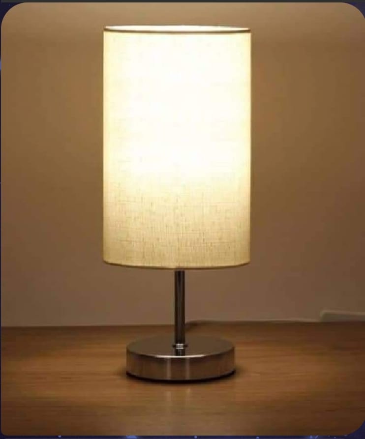 Table lamp with a beige shade on a wooden surface