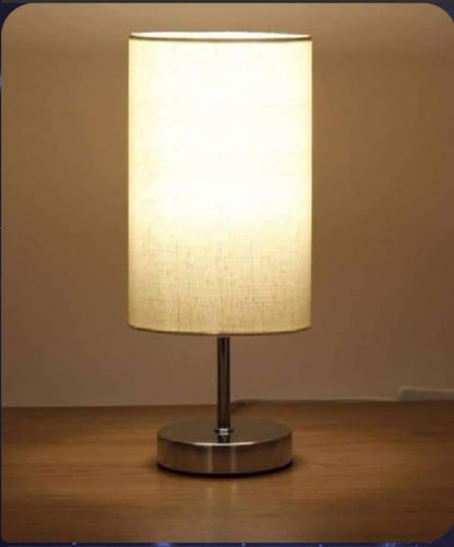 Table lamp with a beige shade on a wooden surface