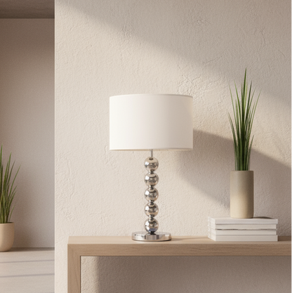 Modern interior with a lamp and plants on a wooden table by large windows.