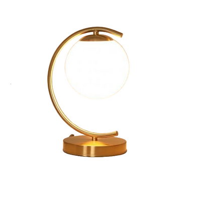 Gold table lamp on a nightstand with a soft light